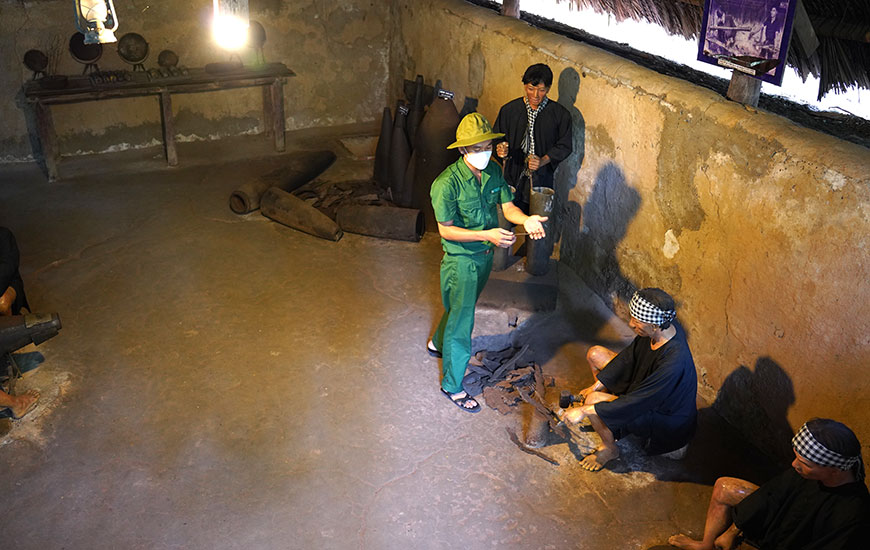 Travellers perusing a historical recreation of a munitions factory within the tunnels.